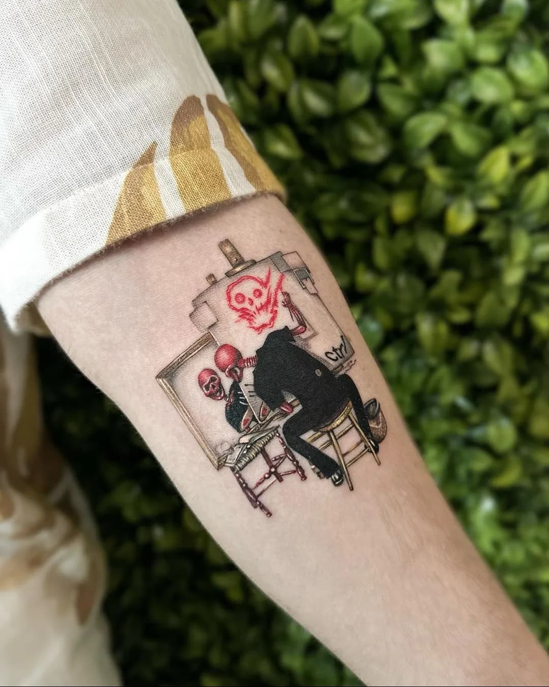 Tatuaj fine line pe antebraț cu o scenă suprarealistă și un craniu roșu