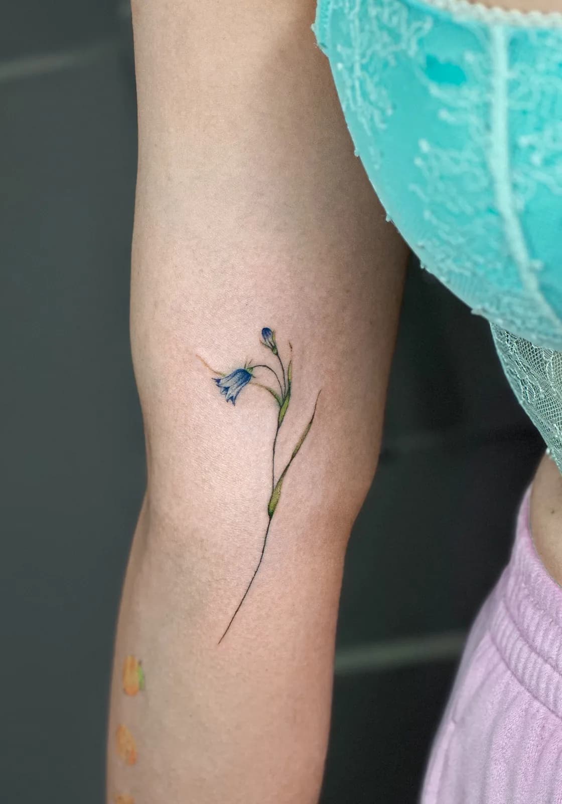 Tatuaj fine line pe braț cu o floare de clopoțel albastru