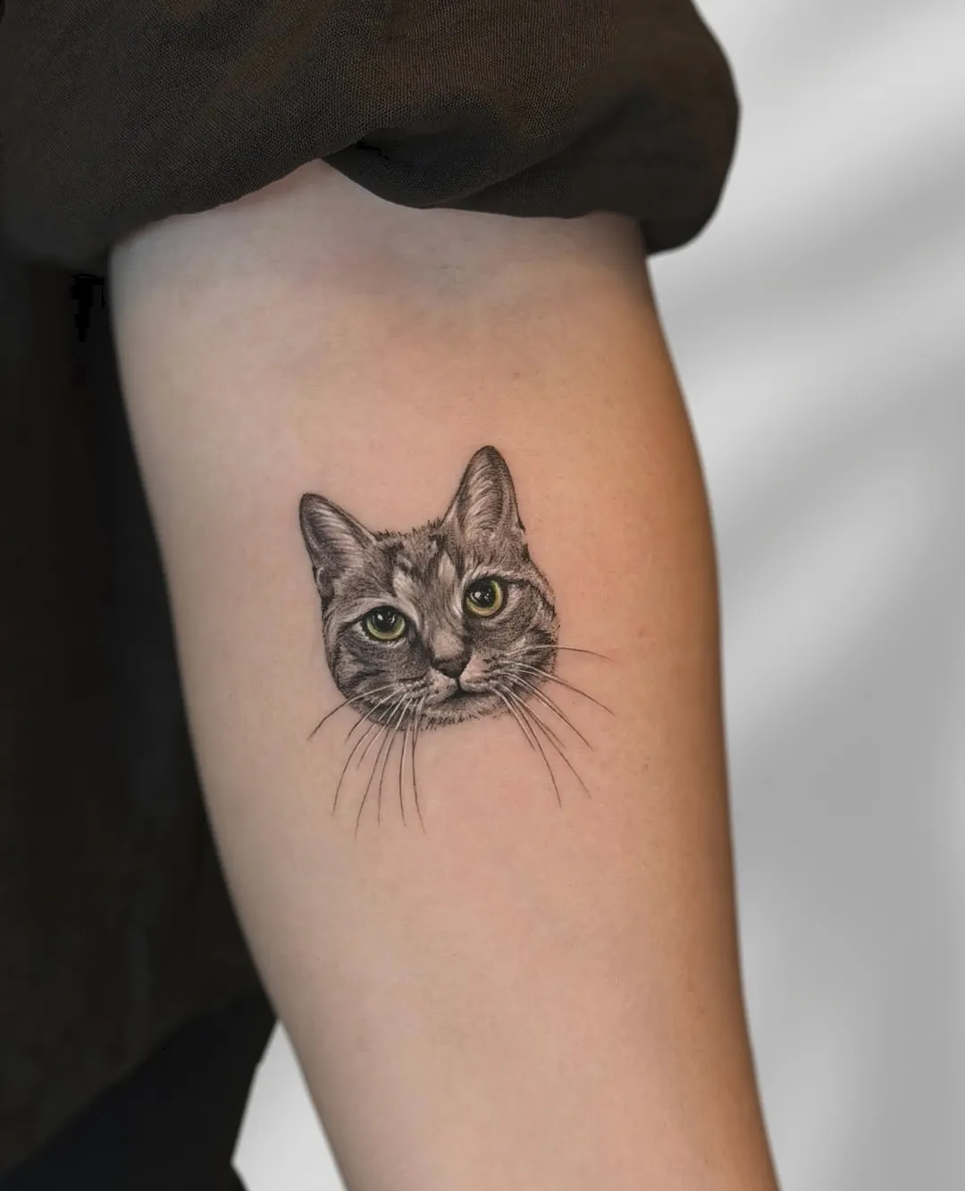 Tatuaj realist alb-negru pe braț cu capul unei pisici