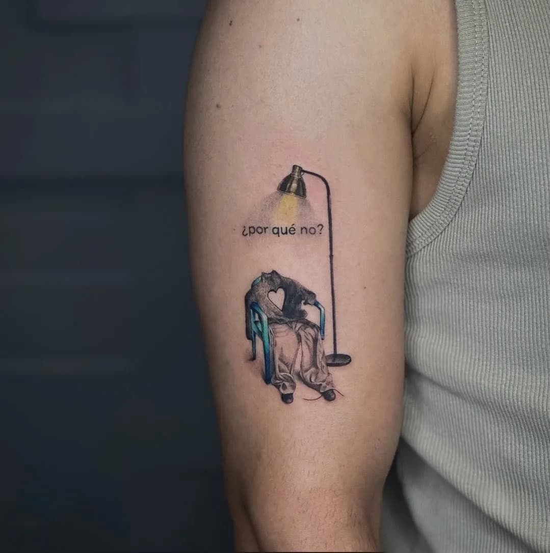 Tatuaj color pe braț cu un scaun sub o lampă și textul ¿por qué no?